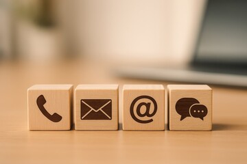 Wooden blocks with communication icons displayed on a table.