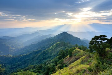 Obraz premium Golden sunlight breaks through dramatic cloud formations, illuminating a vast, rolling mountain landscape covered in lush green vegetation, evoking a sense of peace and grandeur.
