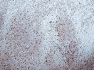 Uncooked white rice grains pattern. Food staple background or texture, ideal for culinary themes or health and nutrition concepts.