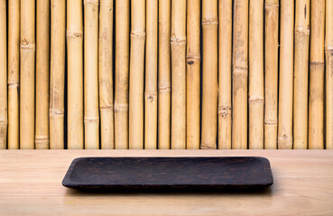 Empty sushi board on wood table with bamboo background. Top view of plank wood for graphic stand product, interior design or montage display your product.