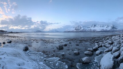 Snowy shoreline meets a tranquil fjord at dawn.