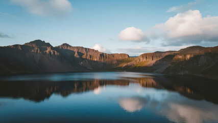 Naklejka premium Calm Mountain Lake with Reflections Under a Serene Sky
