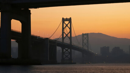 Sunset Silhouette of a Suspension Bridge Over Water