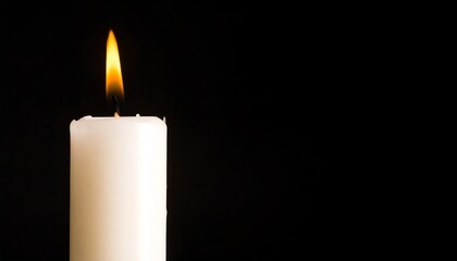 Single white candle with burning flame against a black background.