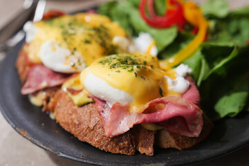 Delicious eggs benedict with greens in a cozy restaurant