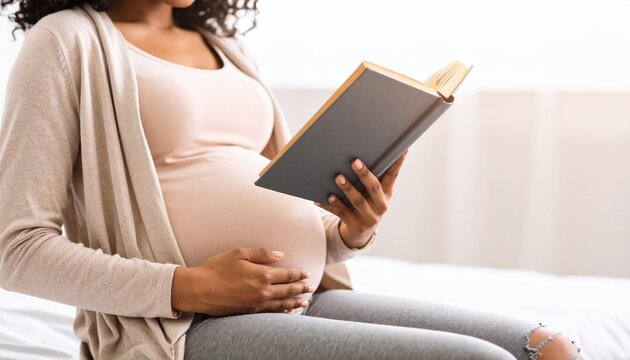 Pregnant woman reading book in casual outfit.