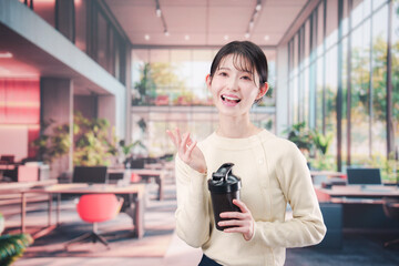 オフィスでマイボトルを持ち歩く若い女性