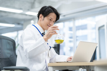 実験をする若い白衣の男性研究者
