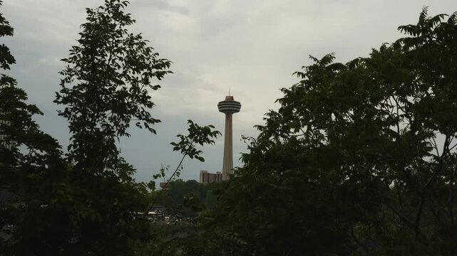 Dramatic shot of the Skylon Tower rising above the trees on an overcast day near Niagara Falls, Canada.
