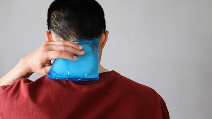 身体を保冷剤で冷やす人物の後ろ姿