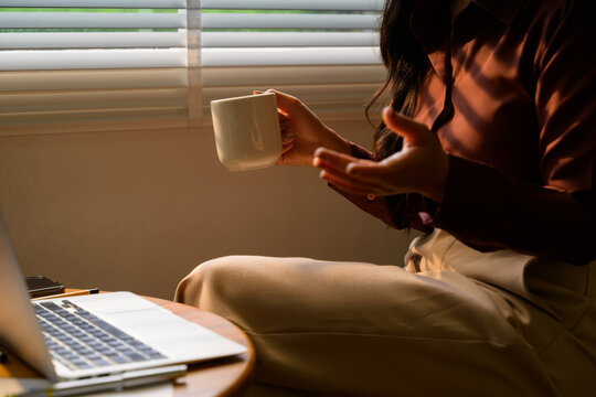 Businesswoman having a video call while drinking coffee at home