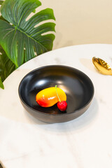 black bowl contains fruit