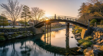 Fototapeta premium Scenic Japanese Wooden Bridge over Clear River at Golden Hour Sunset