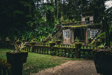 Moss-covered stone structure with fountains spraying arcs of water in Paronella Park.