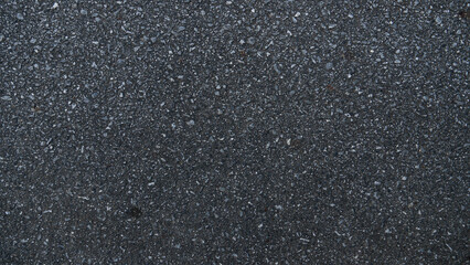 Background and textured detail of fine gravel flakes on asphalt road surface. For use on asphalt road and other.