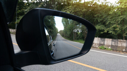 Inside view of mirrors wing. Asphalt road that stretches up the hill. Side of the road is a concrete road with a guard lane. Surrounded by lush green forests. Provides shade and is ideal for tourism.