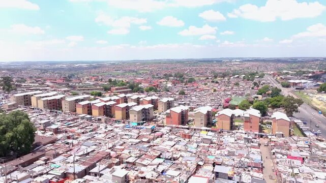 Aerial boom shot revealing Alexandra Township, Johannesburg, South Africa, on a sunny day with scattered clouds