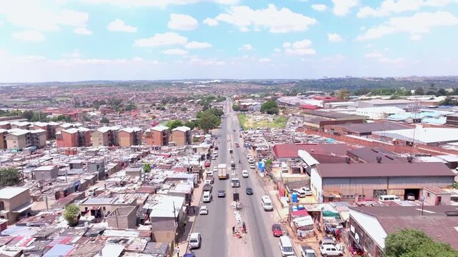 Aerial zoom in shot of informal settlement in Alexandra Township, Johannesburg, South Africa, on a sunny day with scattered clouds