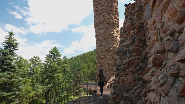 Young Woman Walking Under Walls and Towers of Bishop Castle, Colorado USA