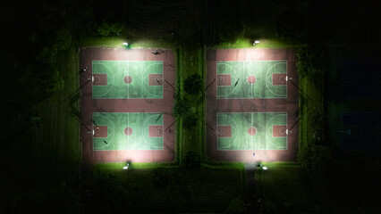 Aerial View of Illuminated basketball Sports Fields at Night from Above