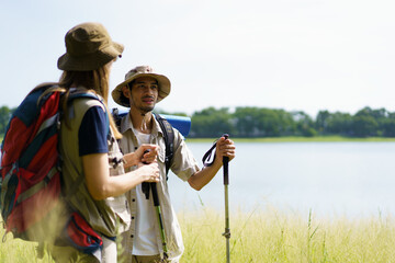 Man and woman are enjoy seeing a beautiful landscape and lake view while hiking.