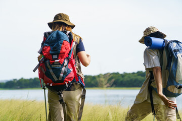 Man and woman are enjoy seeing a beautiful landscape and lake view while hiking.