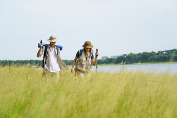 Man and woman are enjoy seeing a beautiful landscape and lake view while hiking.