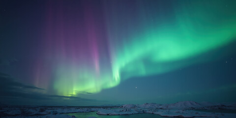 Naklejka premium A shimmering aurora borealis effect sweeps diagonally across a dark indigo canvas, its vibrant hues of green, purple, and teal