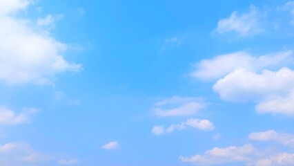 Clear blue sky and fluffy white clouds. Nature sky with soft clouds focus effect, peaceful nature background.