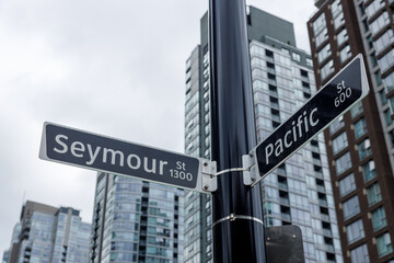 Obraz premium Street signs at intersection of Seymour Street 1300 block and Pacific Street 600 block in Vancouver's downtown core, surrounded by modern glass high-rise residential towers