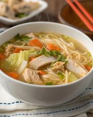 🍲 Warm noodle soup with chicken, cabbage and fresh broth on a wooden table 