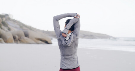 Fitness, back and woman with stretching on beach to start running, cardio workout and muscle relief. Athlete, person and arm warm up on seashore for getting ready, exercise preparation and training