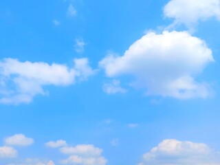 Landscape blue sky with scattered clouds and bright sunshine. Blue sky background with white clouds in summer. Soft white clouds float in the clear blue sky. Clear blue sky, bright spring.