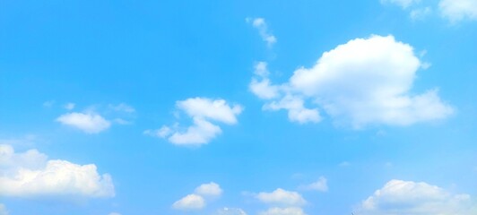 Clear blue sky and fluffy white clouds. Nature sky with soft clouds focus effect, peaceful nature background.
