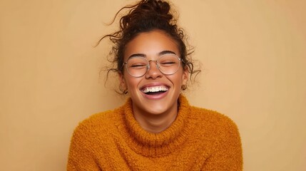 casual cheerful woman with eyeglasses smiling at camera on cream background close up of happy young woman laughing with eyeglasses beautiful girl having fun with closed eyes showing a big grin no log