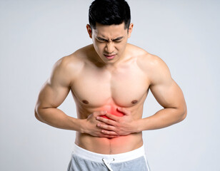 Man age 28 standing with both hands on stomach, wincing in pain, studio lighting