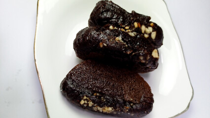 Dark Chocolate Date Energy Bites with Nut Pieces on White Plate