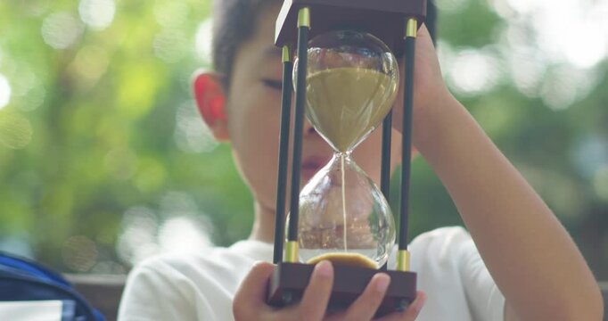 A child holding a sand timer.