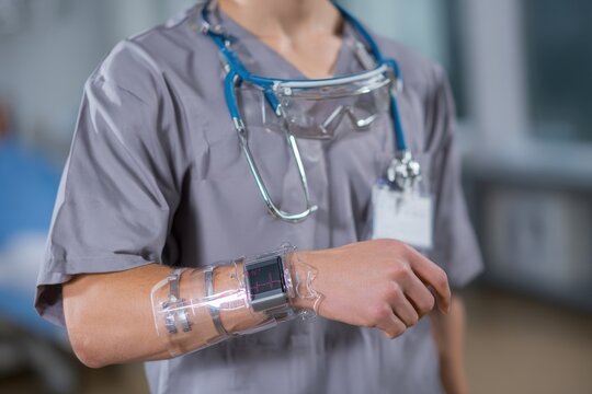 Healthcare worker utilizes innovative wearable technology for patient monitoring in a clinical setting during daytime hours