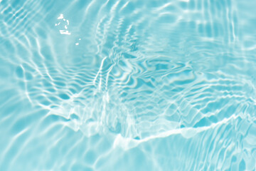 Blue water with ripples on the surface. Defocus blurred transparent blue colored clear calm water surface texture with splashes and bubbles. Water waves with shining pattern texture background.