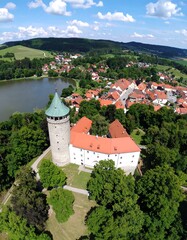 Obraz premium Aerial view of a castle nestled in a verdant landscape, overlooking a town and lake