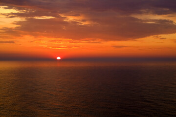 The setting sun has reached the horizon over the Baltic Sea, as seen from the village of Ustronie Morskie, Poland