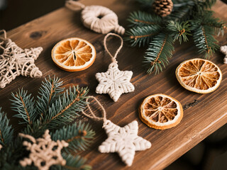 Rustic Christmas decorations with dried orange slices, macrame stars, and pine branches arranged on a wooden table in a cozy holiday setting