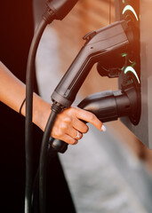 Charging an electric vehicle at a public station during daylight in a modern setting