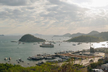 Scenery of Labuan Bajo harbor with boat sailing in the ocean and the cityscape, Indonesia tourist destination.