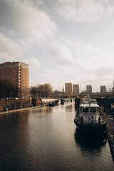 Naklejka premium A boat is floating on a river near a city
