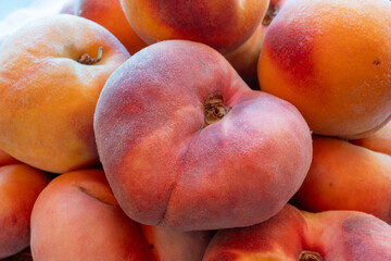 Fresh ripe sweet yellow and flat peaches Prunus persica or doughnut peach or Saturn peach