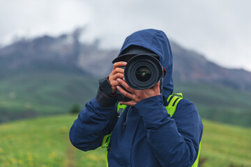 Woman hiker  taking photo on grassland mountain top