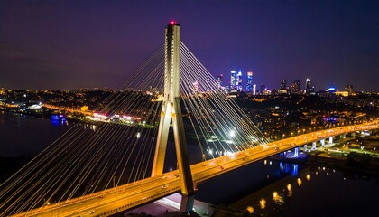Fototapeta premium Illuminated cable-stayed bridge over a river at night.