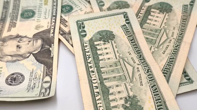 Video of twenty (20$) dollar bills falling on white surface.
